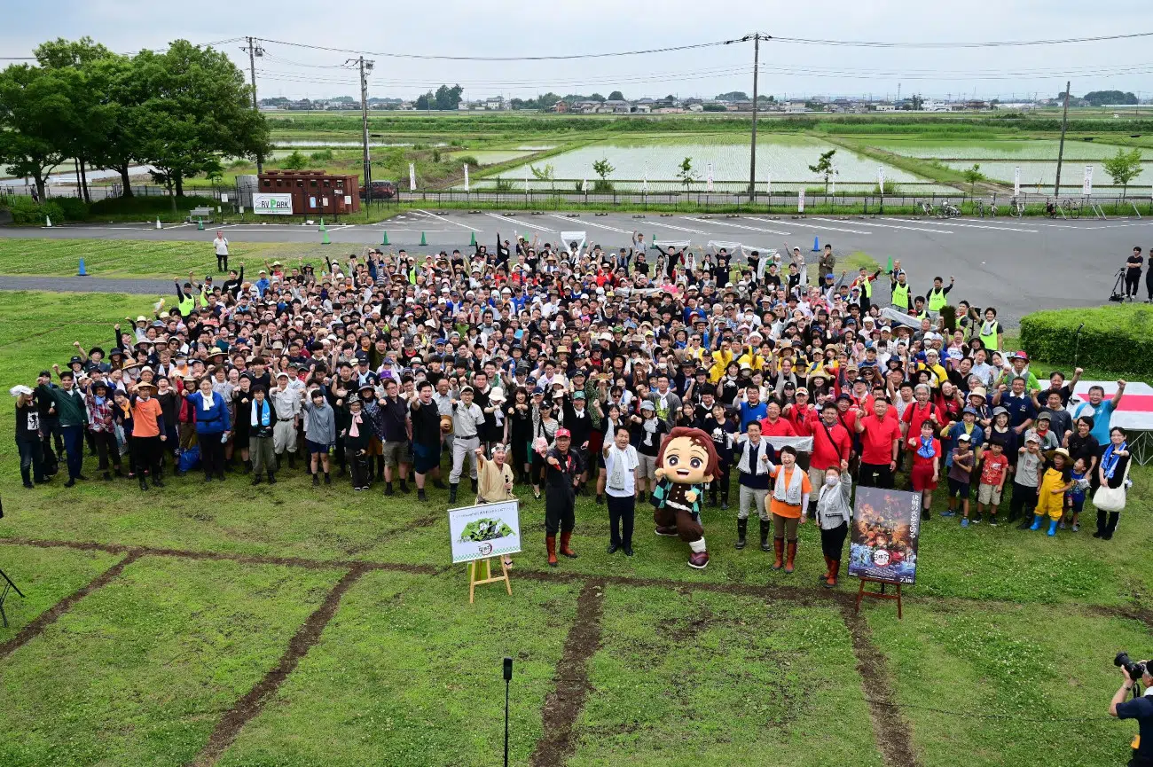 Rice planting volunteers at the Demon Slayer Rice Paddy Art in Gyoda, Japan