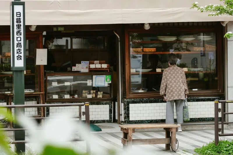 Grandma looks into a window shop in Japan