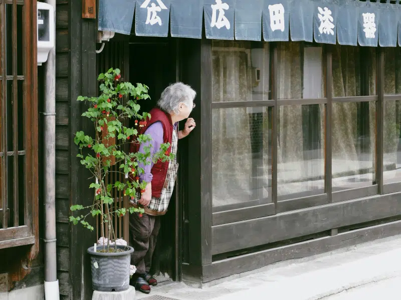 Grandma looking out from a door in Japan